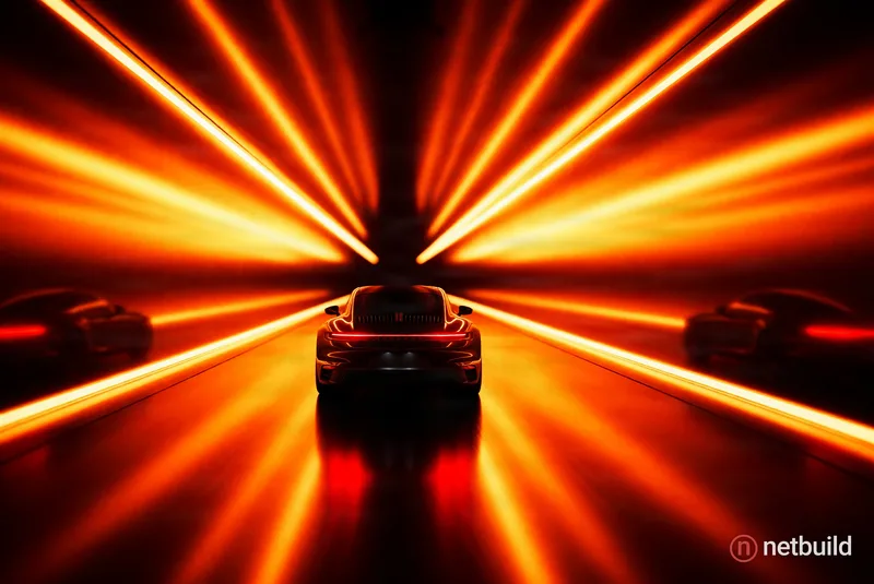 A dark sports car drives down the center of a mirrored tunnel illuminated by intense orange and golden radial light beams. The glowing red tail lights...